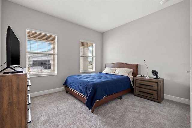 bedroom with light colored carpet and multiple windows