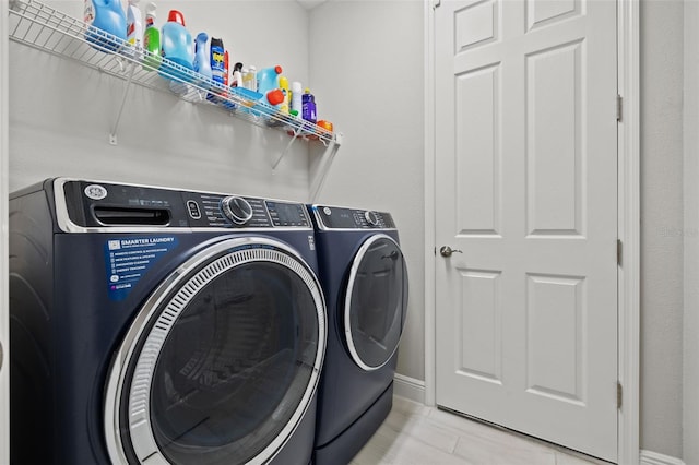 laundry room with washing machine and clothes dryer and light tile patterned flooring