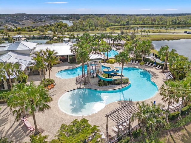 view of swimming pool with a patio area, a water view, and a water slide