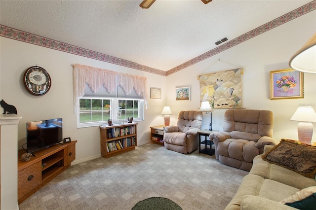 carpeted living room featuring ceiling fan, vaulted ceiling, and a textured ceiling