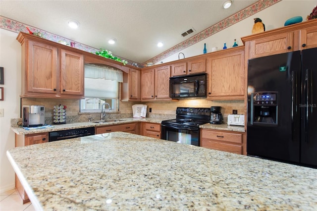 kitchen featuring sink, light tile patterned floors, black appliances, and backsplash