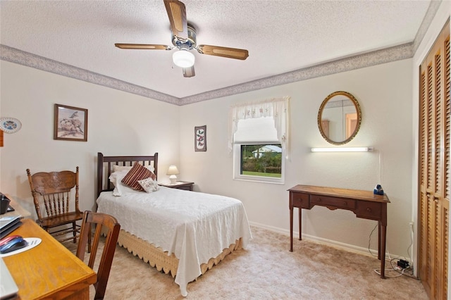 carpeted bedroom with a textured ceiling, ceiling fan, and a closet