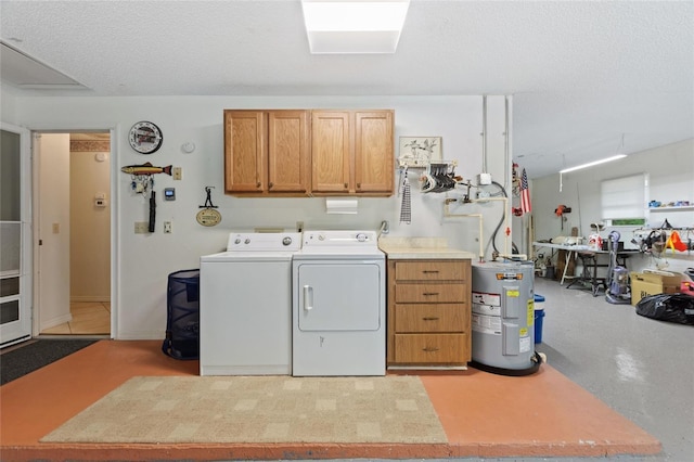 laundry room featuring water heater, cabinets, washer and dryer, and a textured ceiling