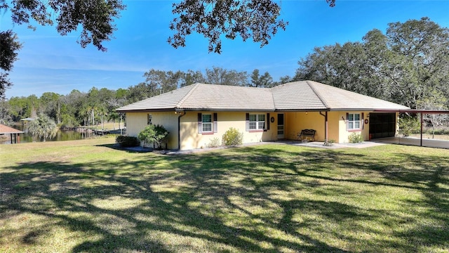 view of front of property featuring a front yard, a carport, and a water view