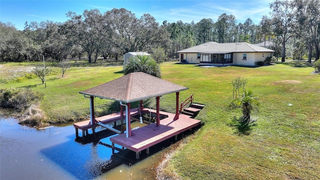 view of dock featuring a water view and a yard