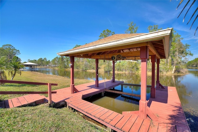 view of dock featuring a water view and a yard