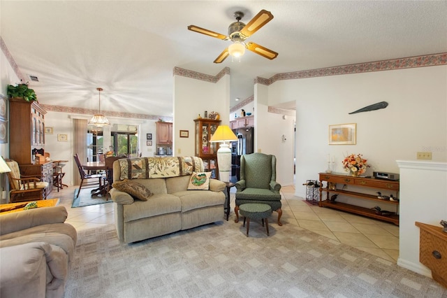 living room featuring lofted ceiling, light tile patterned floors, a textured ceiling, and ceiling fan