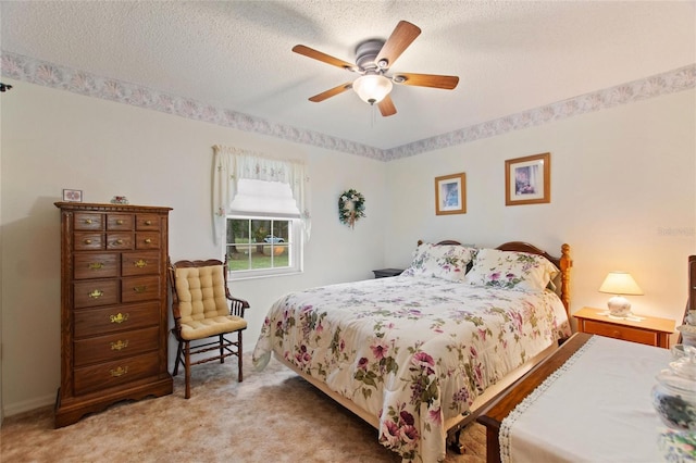 bedroom featuring ceiling fan, light colored carpet, and a textured ceiling