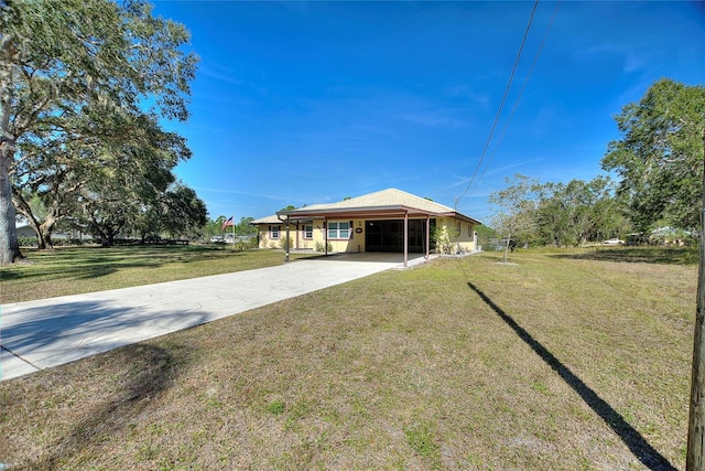 rear view of property with a carport and a yard