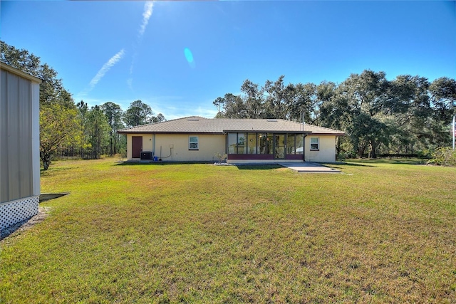 rear view of property with a patio, a yard, and central air condition unit