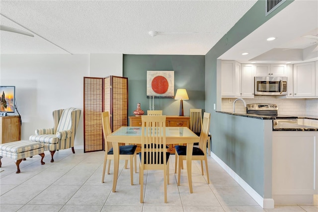 tiled dining room with a textured ceiling