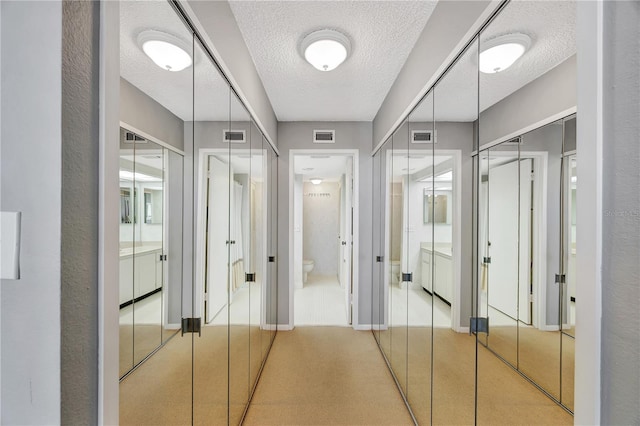 hall featuring a textured ceiling