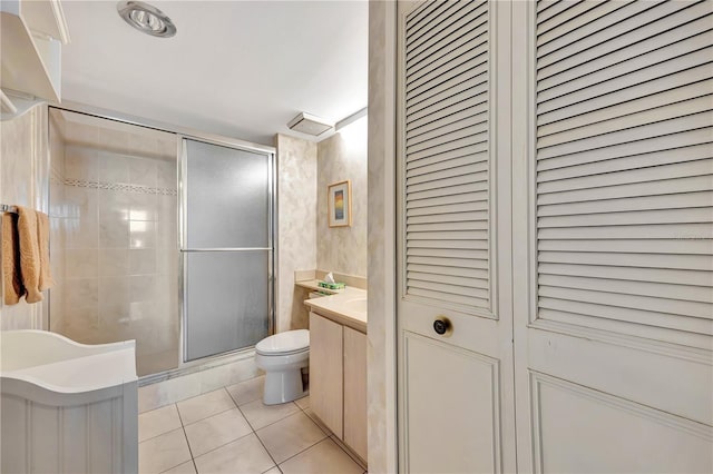 bathroom with walk in shower, vanity, tile patterned floors, and toilet