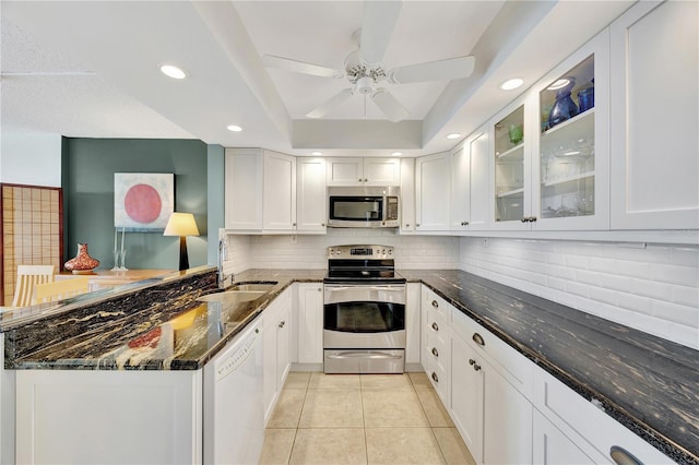 kitchen featuring sink, light tile patterned floors, appliances with stainless steel finishes, a raised ceiling, and white cabinets