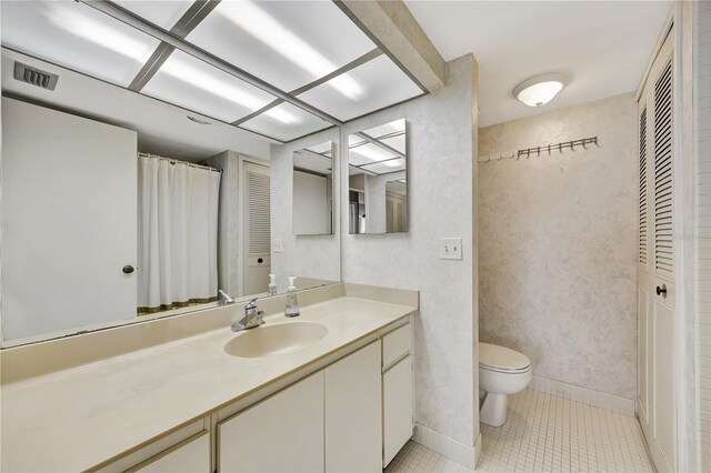 bathroom with vanity, tile patterned floors, and toilet