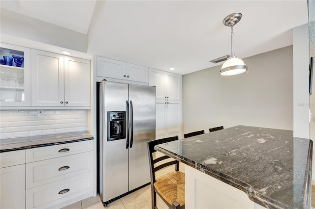 kitchen with white cabinetry, a breakfast bar area, and stainless steel fridge with ice dispenser