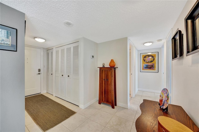 tiled foyer entrance featuring a textured ceiling