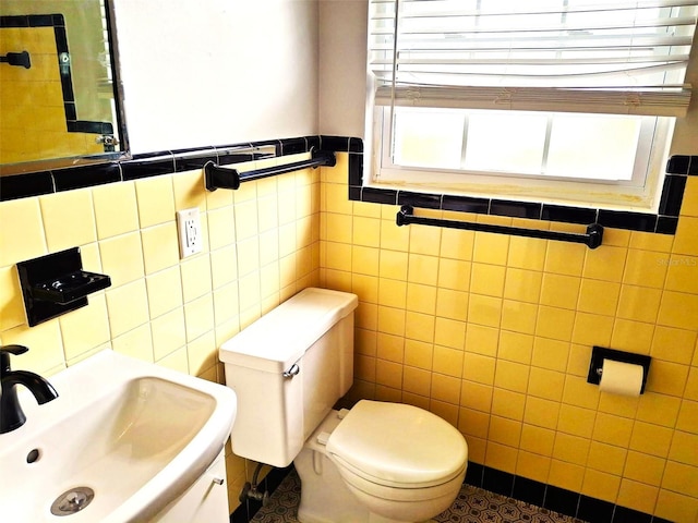 bathroom featuring sink, tile walls, and toilet