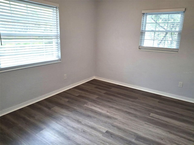 unfurnished room with a healthy amount of sunlight and dark wood-type flooring