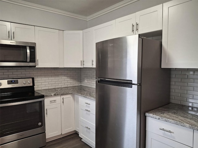 kitchen with white cabinetry, backsplash, ornamental molding, and stainless steel appliances