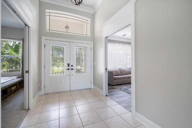 entrance foyer featuring light tile patterned floors, ornamental molding, and french doors