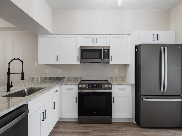 kitchen with white cabinetry, stainless steel appliances, and sink