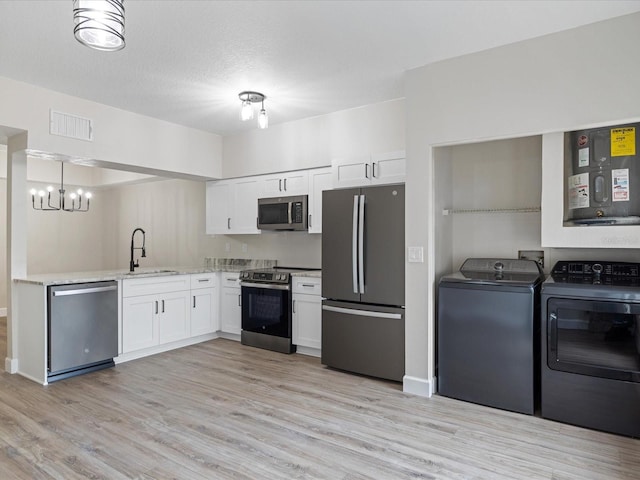 kitchen featuring sink, washer and clothes dryer, white cabinets, and appliances with stainless steel finishes