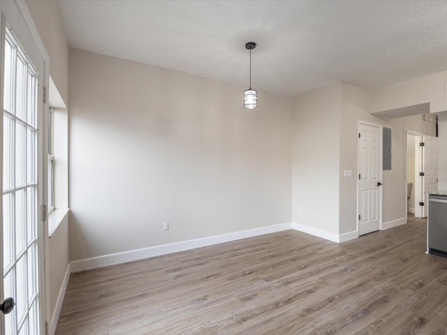 unfurnished room with electric panel and light wood-type flooring