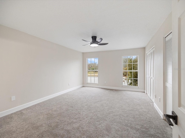 spare room with ceiling fan and carpet