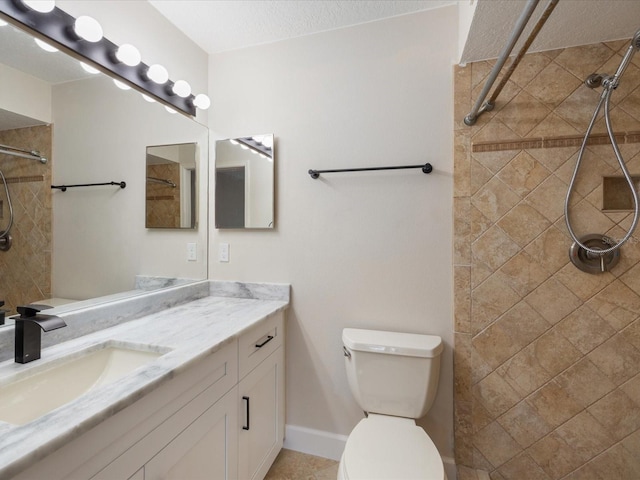 bathroom featuring vanity, a tile shower, a textured ceiling, and toilet