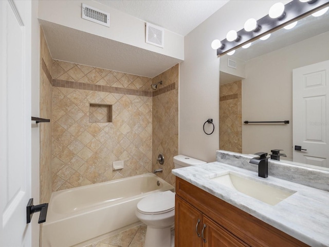 full bathroom featuring tiled shower / bath, vanity, toilet, tile patterned floors, and a textured ceiling