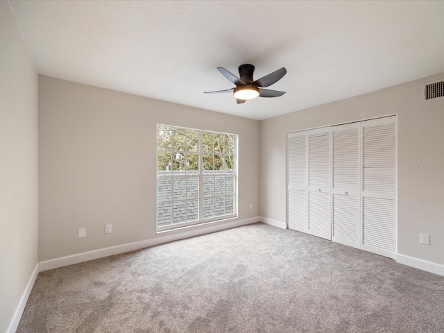 unfurnished bedroom featuring ceiling fan, a closet, and carpet