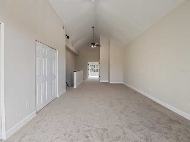 interior space with lofted ceiling, light carpet, and ceiling fan