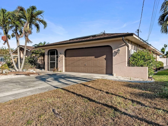 ranch-style house featuring a front yard and a garage