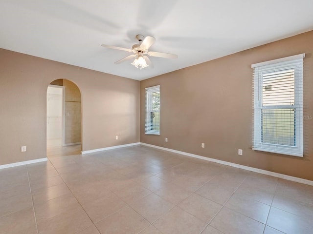 tiled spare room with ceiling fan