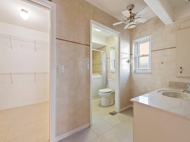 bathroom with tile patterned flooring, vanity, tile walls, toilet, and walk in shower