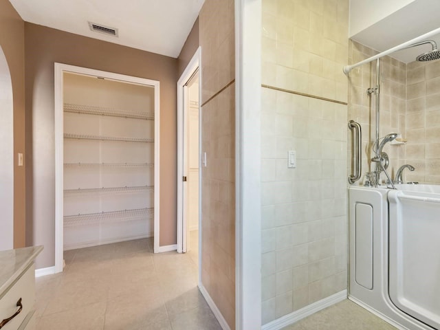 bathroom featuring independent shower and bath, tile patterned floors, and vanity