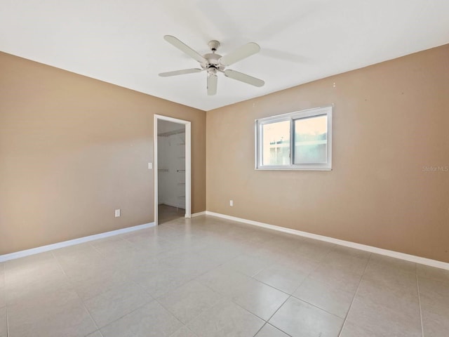 tiled spare room featuring ceiling fan