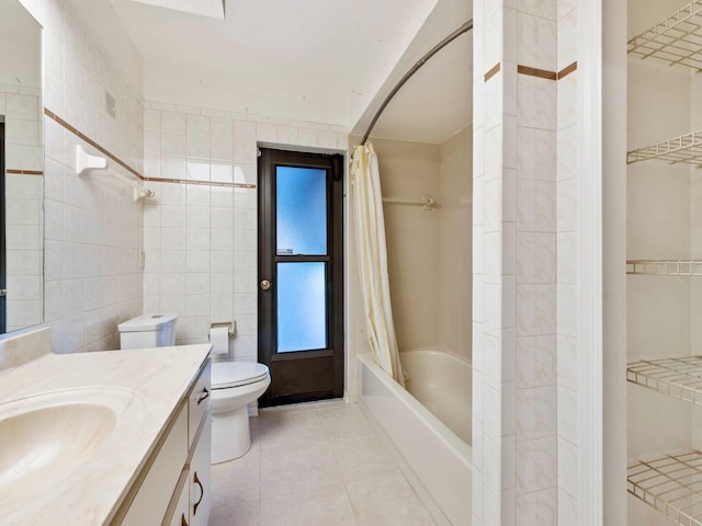 full bathroom featuring tile patterned flooring, vanity, tile walls, toilet, and shower / bath combo with shower curtain