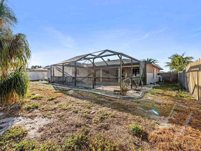 rear view of house featuring a patio area, a lanai, and a pool