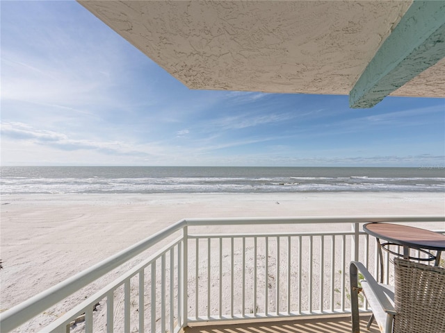 balcony featuring a water view and a view of the beach