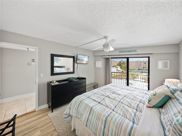 bedroom with ceiling fan, access to exterior, a textured ceiling, and light hardwood / wood-style floors