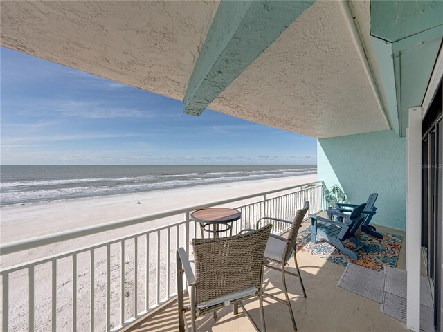 balcony featuring a water view and a view of the beach