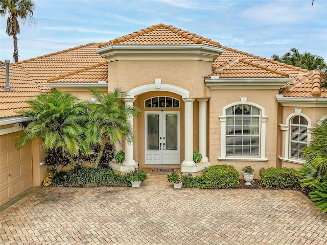 doorway to property with a garage and french doors