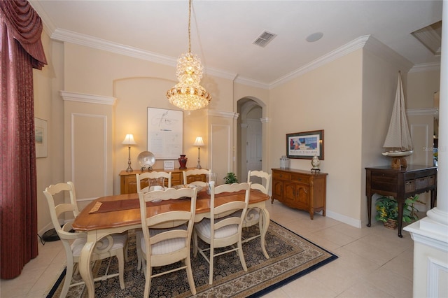 dining space featuring light tile patterned floors, crown molding, a chandelier, and decorative columns