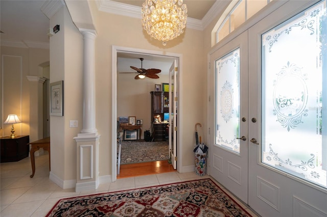 entrance foyer featuring crown molding, light tile patterned floors, ornate columns, and french doors