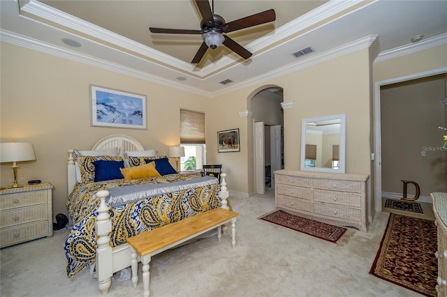 bedroom with ceiling fan, crown molding, light colored carpet, and a raised ceiling