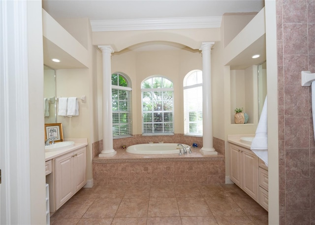 bathroom with ornate columns, ornamental molding, tiled tub, and vanity