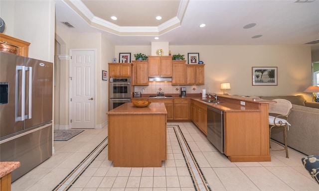 kitchen with light tile patterned floors, kitchen peninsula, appliances with stainless steel finishes, and a breakfast bar area