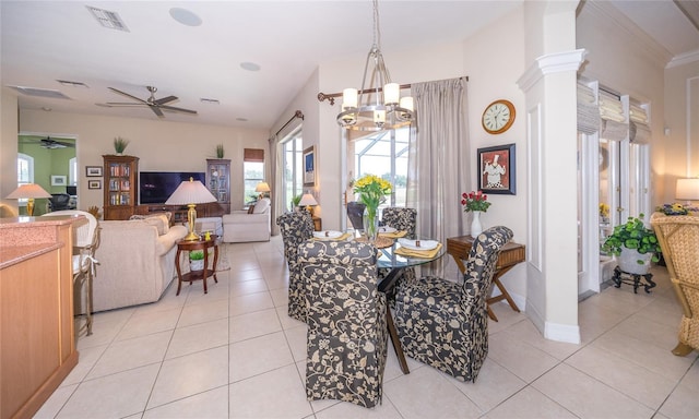 tiled dining area featuring decorative columns and ceiling fan with notable chandelier